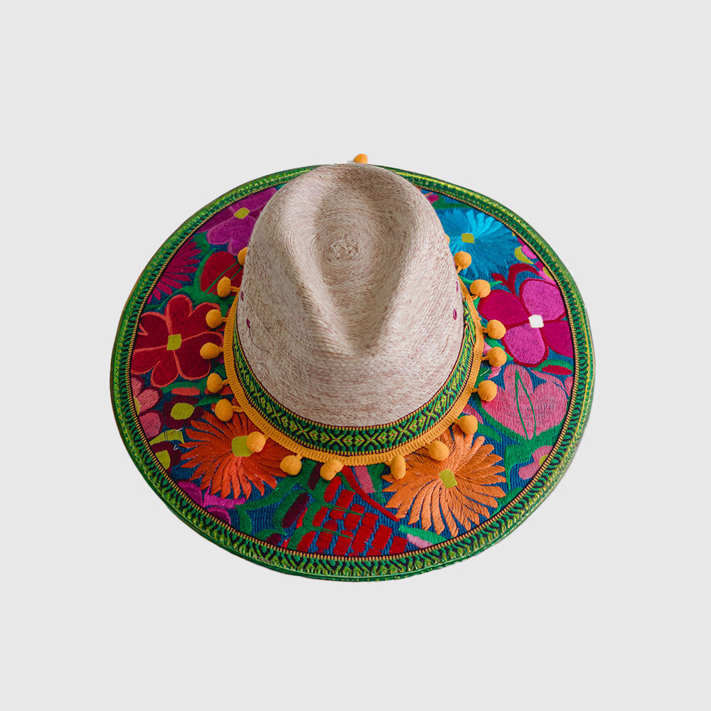 Hat decorated with  yellow, pink and blue embroidered flowers, green ribbon and yellow pompom