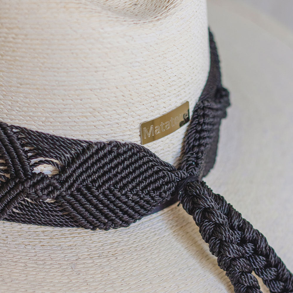 Hat with embroidered black ribbon and small details on the ribbon